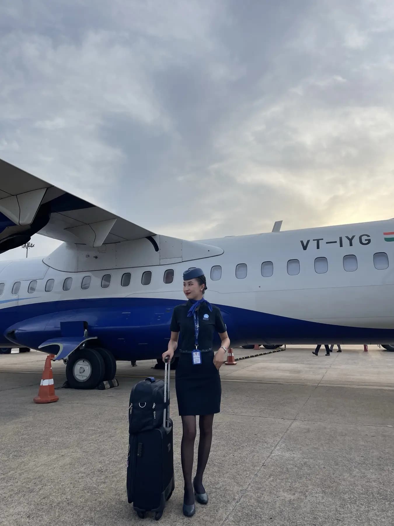 A cabin crew trainee with her trolley bag on the apron
