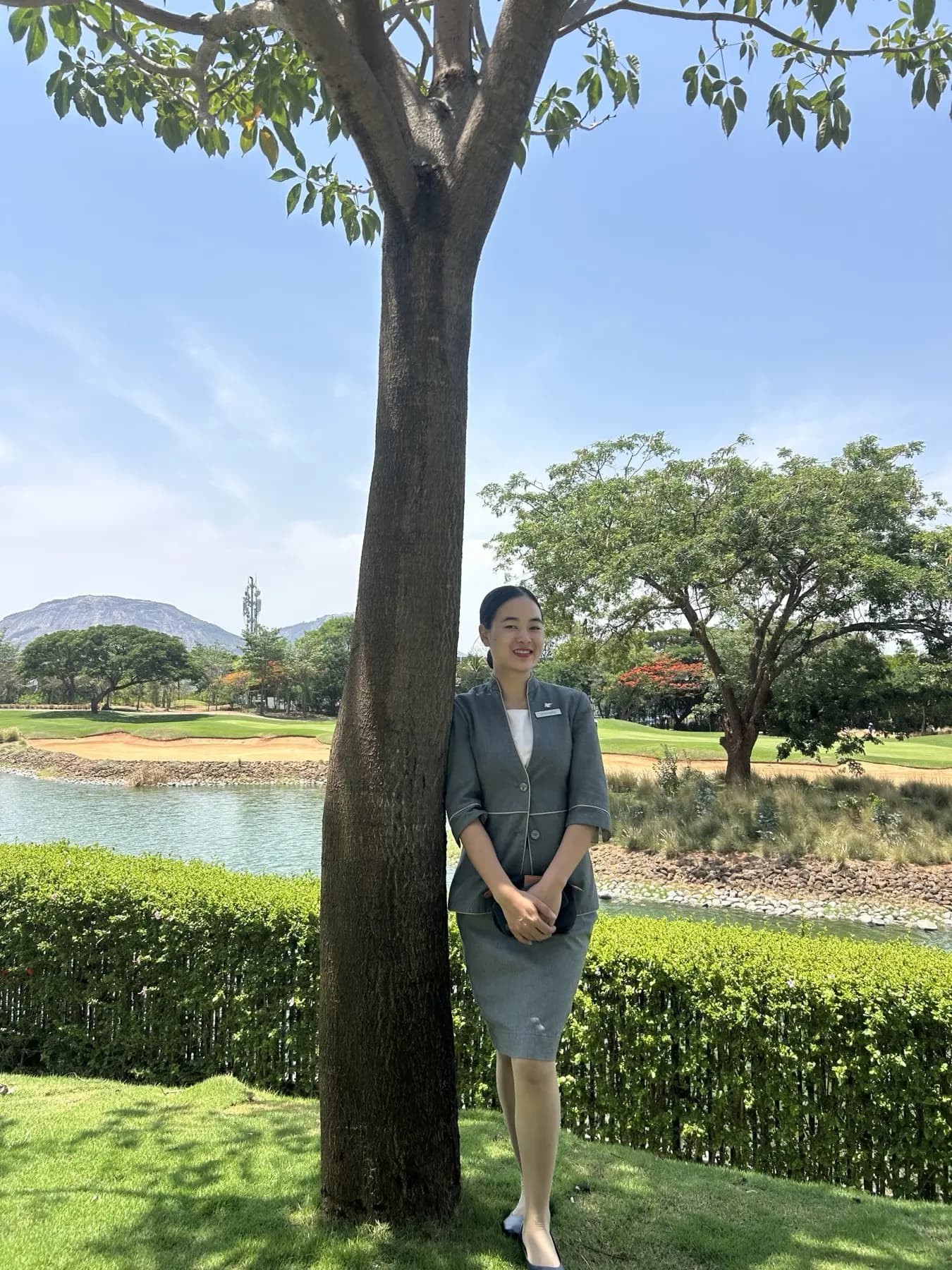A graduate in uniform by a lake